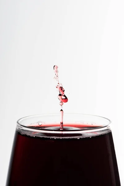 白の近いUに隔離されたガラスの中に落ちる赤ワインの液滴 — ストック写真