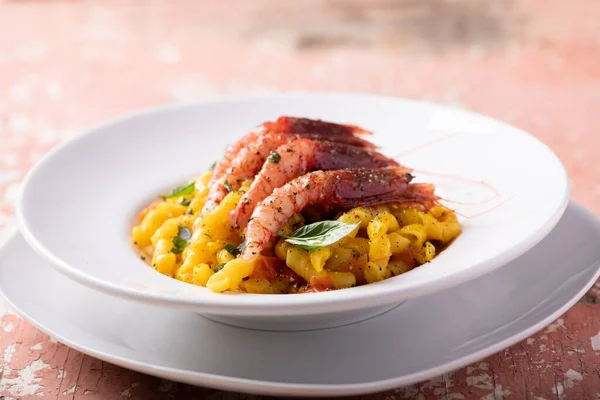 Busiate pasta with red shrimps from mazara del vallo served in a restaurant in Sicily Trapani. Sea Food Pasta