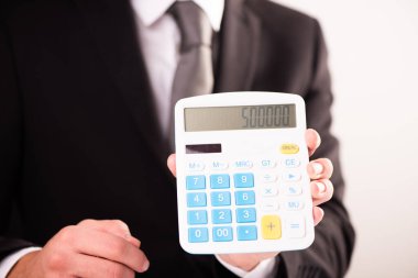 Man holding calculator in hand. Business man showing value on calculator close up