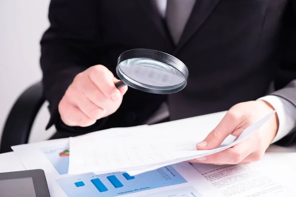 Businessman Examining Document Magnifying Glass Sitting Desk — Stockfoto