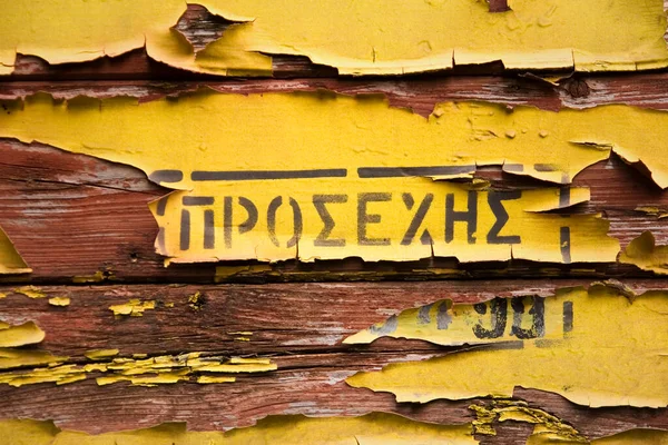 Old Yellow Peeled Paint Wood Surface Word Greek — Stockfoto