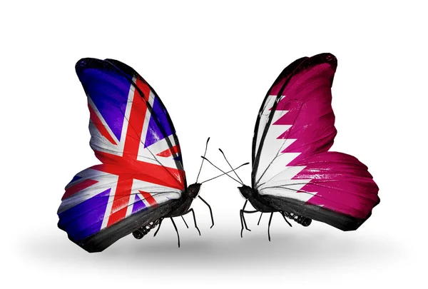 Zwei Schmetterlinge mit Flaggen auf Flügeln als Symbol der Beziehungen zwischen uk und qatar — Stockfoto