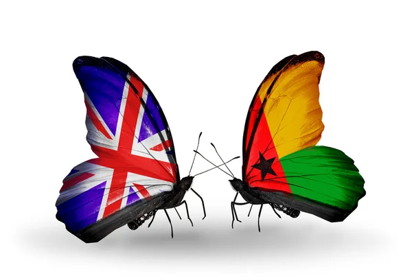 Dwa motyle z flagami na skrzydłach jako symbol uk stosunków i Gwinei bissau — Zdjęcie stockowe