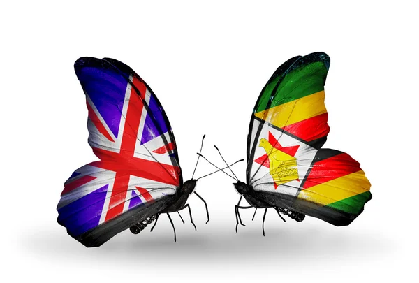 Zwei schmetterlinge mit fahnen auf flügeln als symbol der beziehungen uk und zimbabwe — Stockfoto