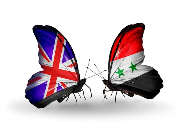 Zwei Schmetterlinge mit Flaggen auf Flügeln als Symbol der Beziehungen zwischen Großbritannien und Syrien — Stockfoto