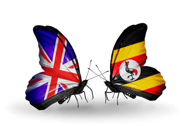 Zwei schmetterlinge mit fahnen auf flügeln als symbol der beziehungen uk und uganda — Stockfoto