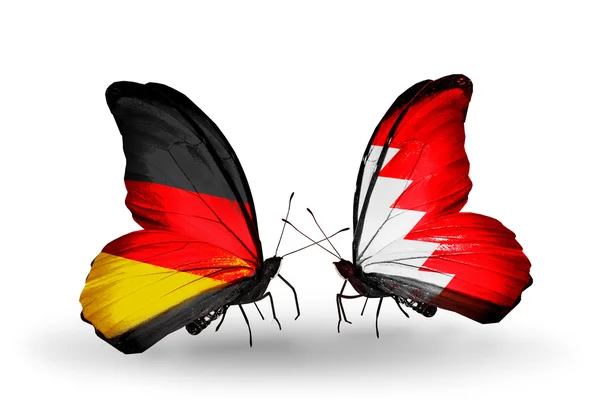 Due farfalle con bandiere sulle ali come simbolo delle relazioni Germania e Bahrein — Foto Stock