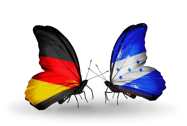 Due farfalle con bandiere sulle ali come simbolo delle relazioni Germania e Honduras — Foto Stock