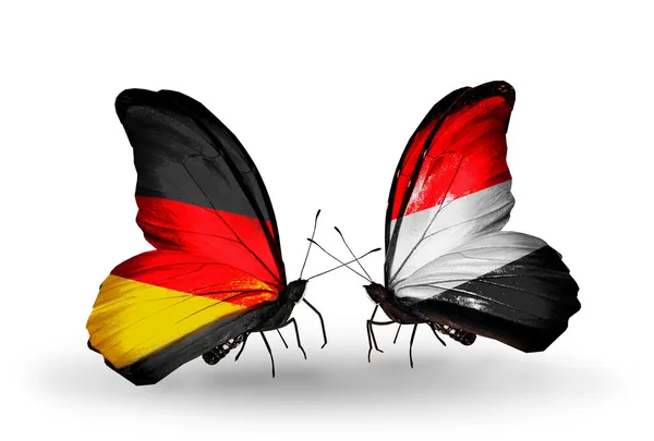 Dva motýli s příznaky na křídlech jako symbol vztahů, Německo a Jemen — Stock fotografie