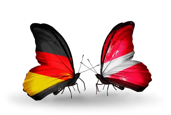 Dos mariposas con banderas en alas como símbolo de relaciones Alemania y Letonia — Foto de Stock