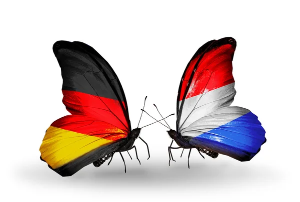 Two butterflies with flags on wings as symbol of relations Germany and Luxembourg — Stock Photo, Image