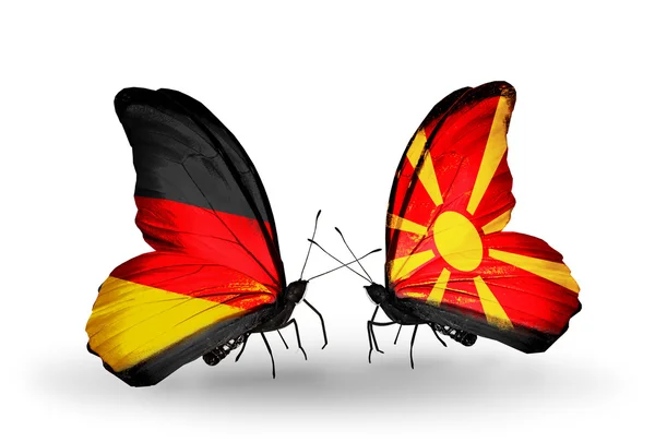 Dva motýli s příznaky na křídlech jako symbol vztahů, Německo a Makedonie — Stock fotografie