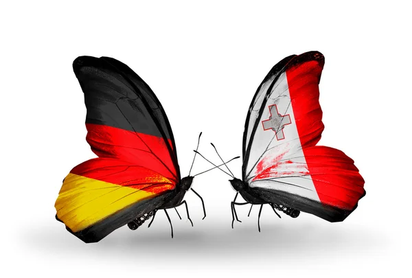 Dwa motyle z flagami na skrzydłach jako symbol stosunków, Niemcy i malta — Zdjęcie stockowe