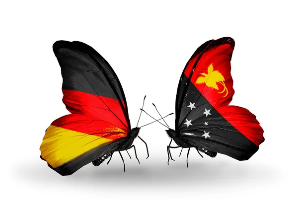 Dva motýli s příznaky na křídlech jako symbol vztahů, Německo a Papua-Nová guinea — Stock fotografie