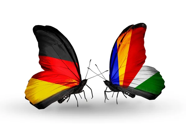 Två fjärilar med flaggor på vingarna som symbol för förbindelserna mellan Tyskland och Seychellerna — Stockfoto