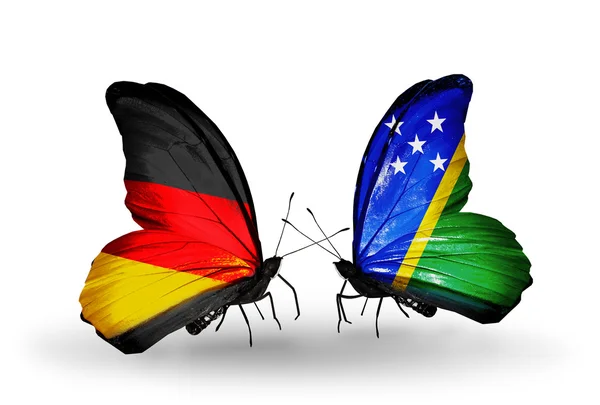 Twee vlinders met vlaggen op vleugels als symbool van betrekkingen Duitsland en solomon eilanden — Stockfoto