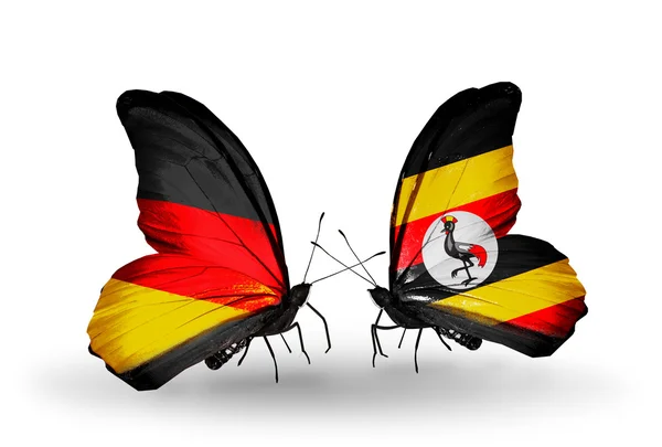 Twee vlinders met vlaggen op vleugels als symbool van betrekkingen Duitsland en Oeganda — Stockfoto