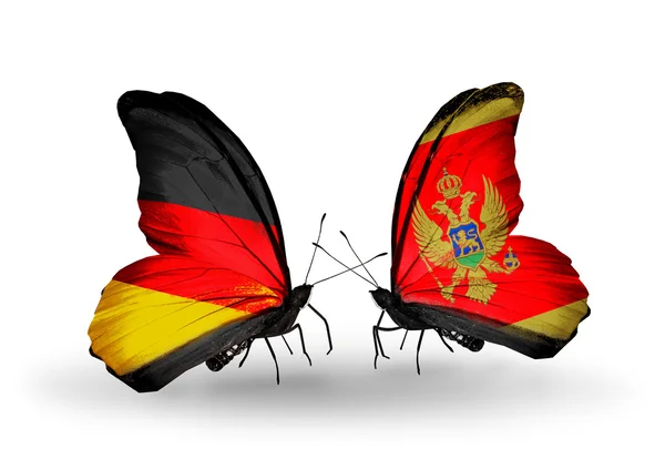 Twee vlinders met vlaggen op vleugels als symbool van betrekkingen Duitsland en montenegro — Stockfoto