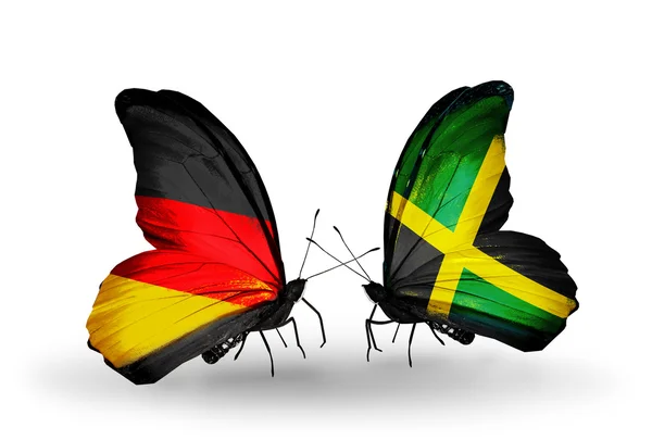 Twee vlinders met vlaggen op vleugels als symbool van betrekkingen Duitsland en jamaica — Stockfoto
