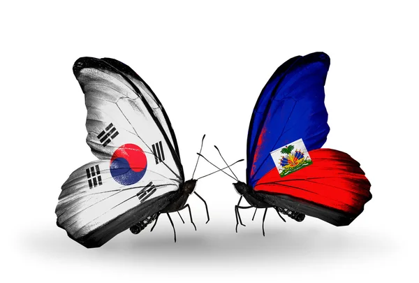 Due farfalle con bandiere sulle ali come simbolo delle relazioni Corea del Sud e Haiti — Foto Stock