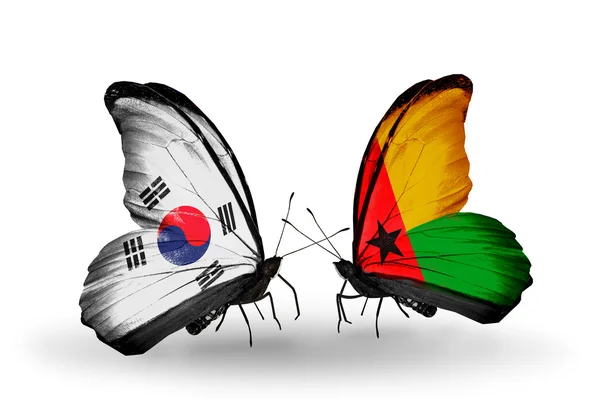 Twee vlinders met vlaggen op vleugels als symbool van betrekkingen Zuid-korea en Guinee-bissau — Stockfoto