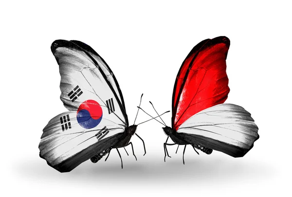 Dva motýli s příznaky na křídlech jako symbol vztahů, Jižní korea a Monako nebo Indonésie — Stock fotografie