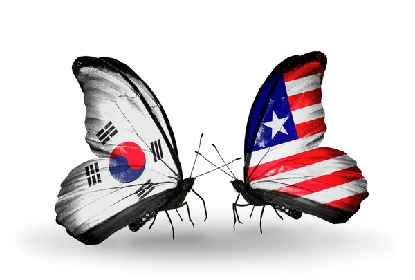 Dva motýli s příznaky na křídlech jako symbol vztahů, Jižní korea a Libérie — Stock fotografie