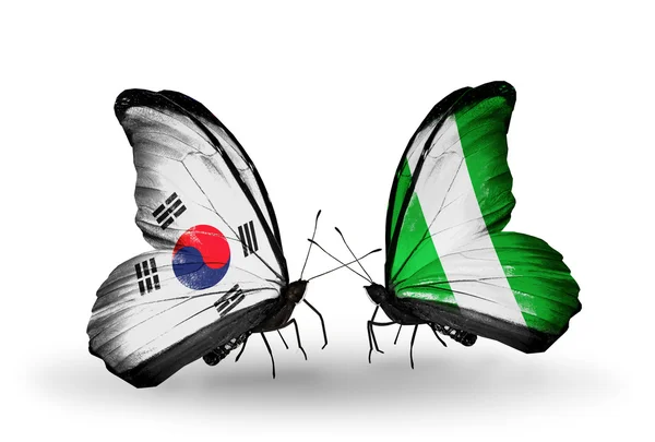 Due farfalle con bandiere sulle ali come simbolo delle relazioni Corea del Sud e Nigeria — Foto Stock