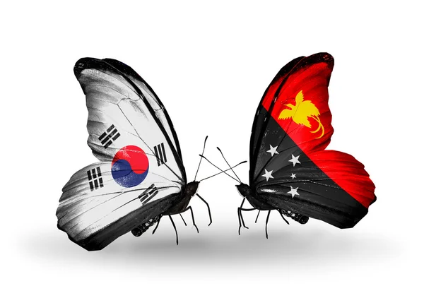 Dva motýli s příznaky na křídlech jako symbol vztahů, Jižní korea a Papua-Nová guinea — Stock fotografie