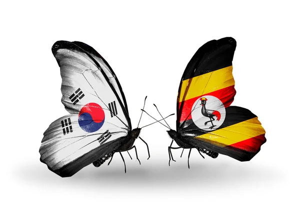 Två fjärilar med flaggor på vingarna som symbol för förbindelserna mellan Sydkorea och uganda — Stockfoto