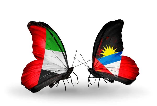 Zwei Schmetterlinge mit Flaggen auf Flügeln als Symbol der Beziehungen uae und antigua und barbuda — Stockfoto