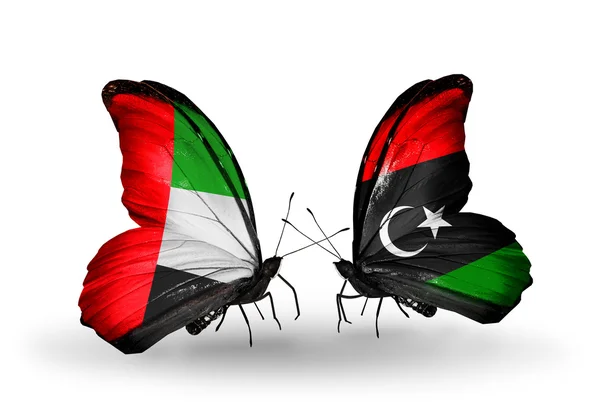 Dwa motyle z flagami na skrzydłach jako symbol Zjednoczonych Emiratów Arabskich stosunków i Libii — Zdjęcie stockowe