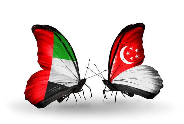 Due farfalle con bandiere sulle ali come simbolo delle relazioni Emirati Arabi Uniti e Singapore — Foto Stock