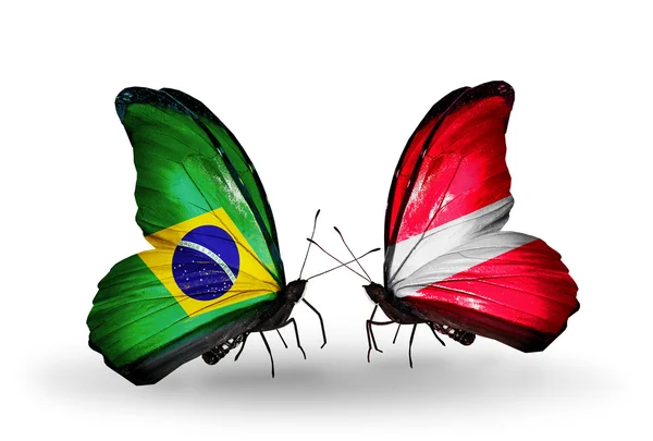 Dva motýli s příznaky na křídlech jako symbol vztahů, Brazílie a Lotyšsko — Stock fotografie