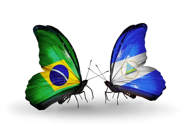 Dos mariposas con banderas en alas como símbolo de relaciones Brasil y Nicaragua — Foto de Stock