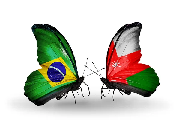 Twee vlinders met vlaggen op vleugels als symbool van de betrekkingen, Brazilië en oman — Stockfoto