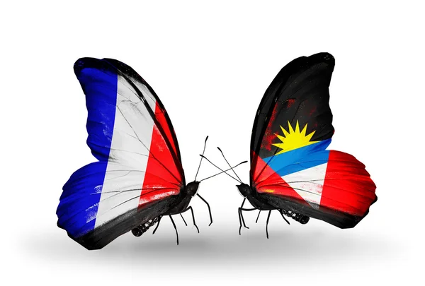 Två fjärilar med flaggor på vingarna som symbol för förbindelserna mellan Frankrike och antigua och barbuda — Stockfoto
