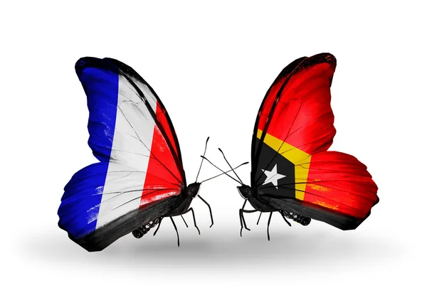 Dos mariposas con banderas en alas como símbolo de relaciones Francia y Timor Oriental —  Fotos de Stock