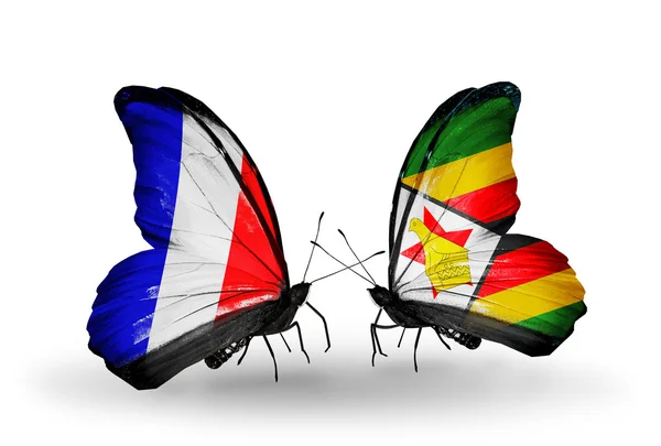 Two butterflies with flags on wings as symbol of relations France and Zimbabwe — Stock Photo, Image