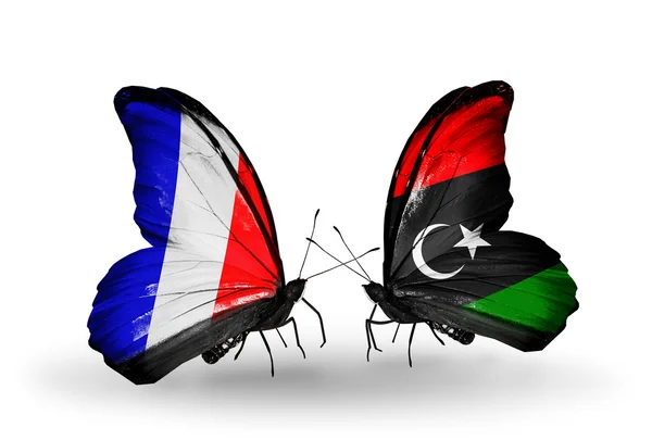 Två fjärilar med flaggor på vingarna som symbol för förbindelserna mellan Frankrike och Libyen — Stockfoto