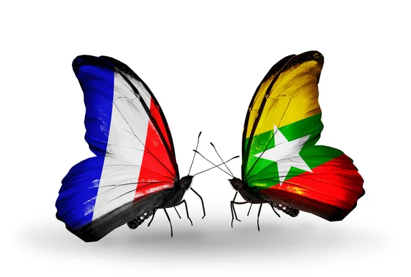 Zwei Schmetterlinge mit Fahnen auf Flügeln als Symbol der Beziehungen zwischen Frankreich und Myanmar — Stockfoto
