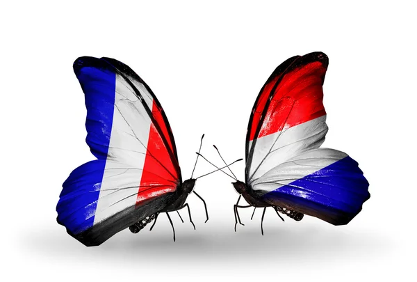 Dos mariposas con banderas en alas como símbolo de relaciones Francia y Holanda — Foto de Stock