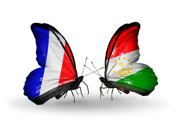 Dos mariposas con banderas en alas como símbolo de relaciones Francia y Tayikistán — Foto de Stock