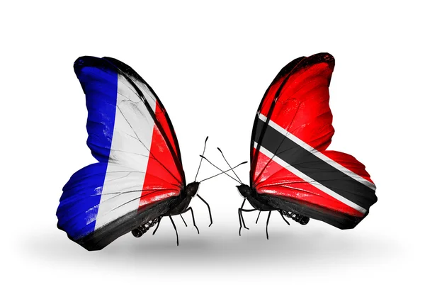 Два метелики з прапорами на крилах як символ відносин, Франція і Долар Тринідаду і Тобаго — стокове фото