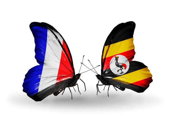 Dos mariposas con banderas en alas como símbolo de relaciones Francia y Uganda —  Fotos de Stock