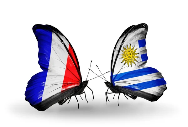 Dos mariposas con banderas en alas como símbolo de relaciones Francia y Uruguay —  Fotos de Stock