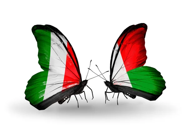 Dos mariposas con banderas en alas como símbolo de relaciones Italia y Madagascar — Foto de Stock