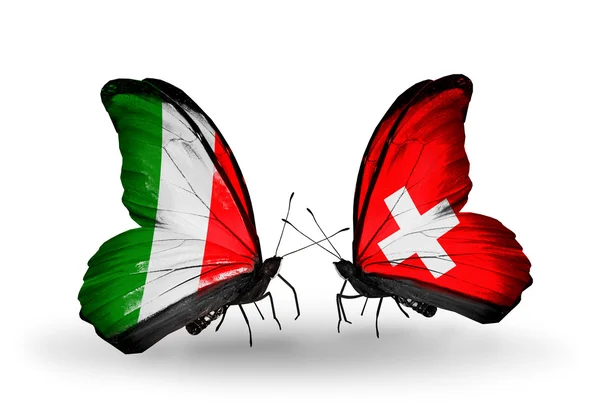 Två fjärilar med flaggor på vingarna som symbol för förbindelserna mellan Italien och Schweiz — Stockfoto