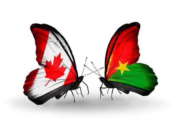 Två fjärilar med flaggor på vingarna som symbol för förbindelserna mellan Kanada och burkina faso — Stockfoto