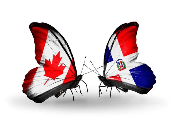 Zwei Schmetterlinge mit Flaggen auf Flügeln als Symbol der Beziehungen canada und dominicana — Stockfoto